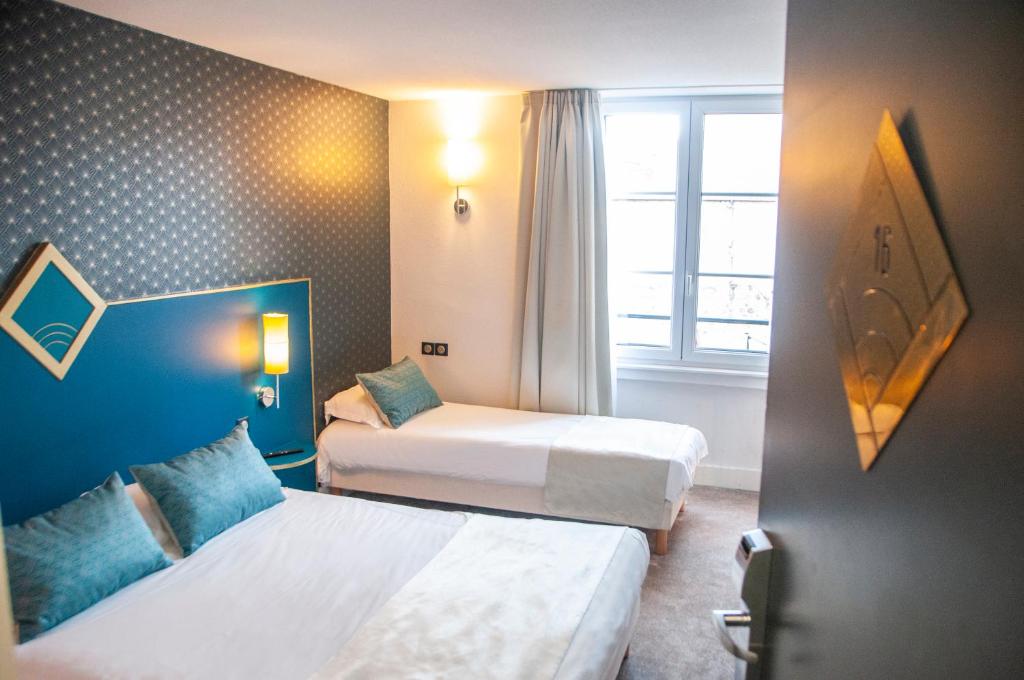 una camera d'albergo con due letti e una finestra di The Originals City, Hôtel Bristol, Le Puy-en-Velay a Le Puy en Velay