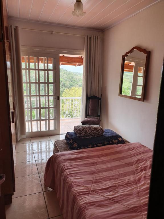 a bedroom with a bed and a mirror on the wall at Casa Mirante Bixo Do Mato in Muçum