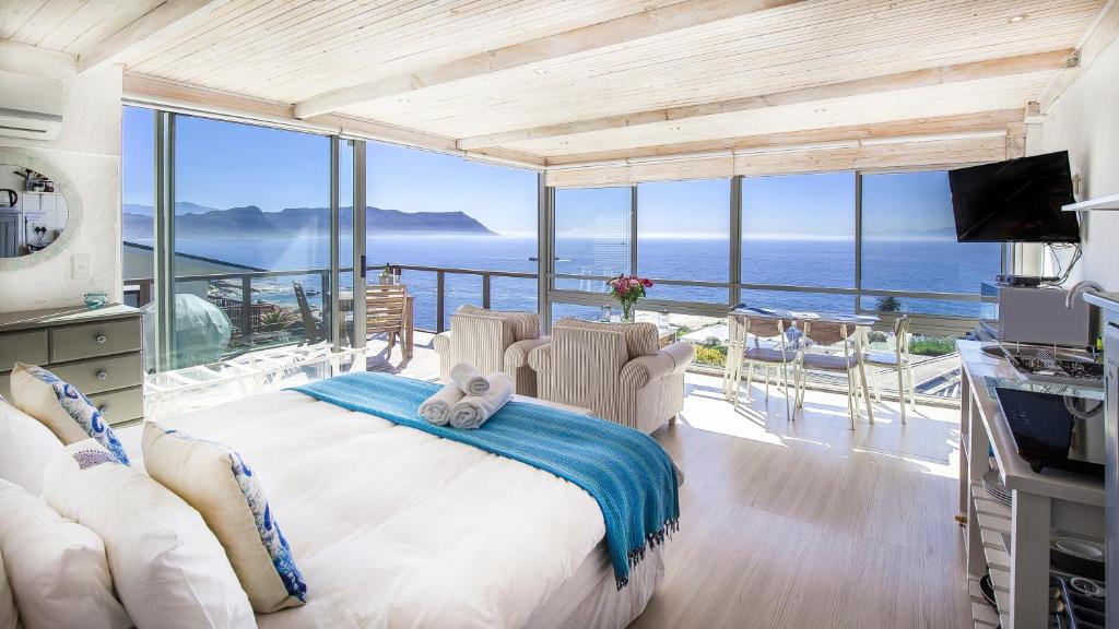 1 dormitorio con 1 cama grande y vistas al océano en Penguins View Guesthouse, en Simonʼs Town