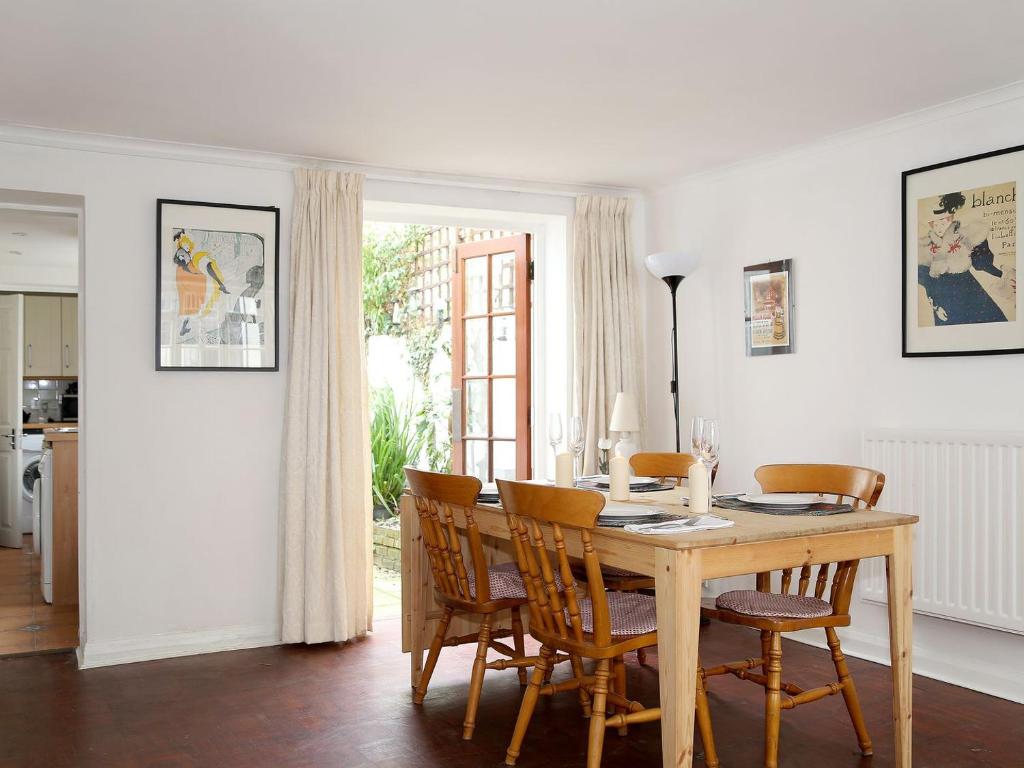 una sala da pranzo con tavolo e sedie in legno di North Laine Cottage a Brighton & Hove