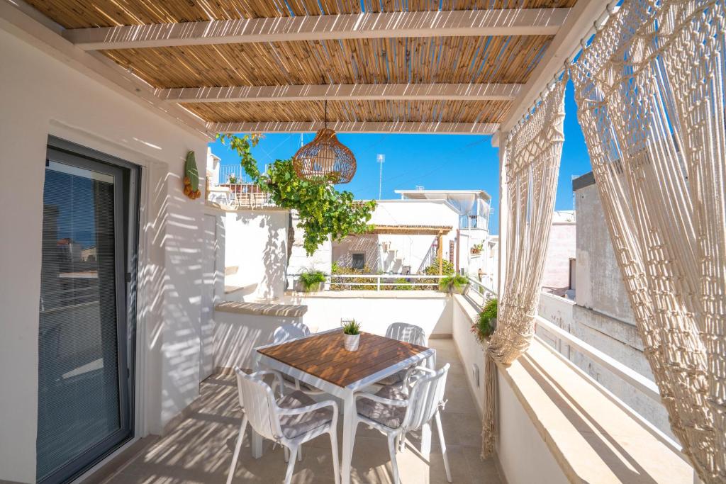 a patio with a table and chairs on a balcony at Marianna 25 in Polignano a Mare