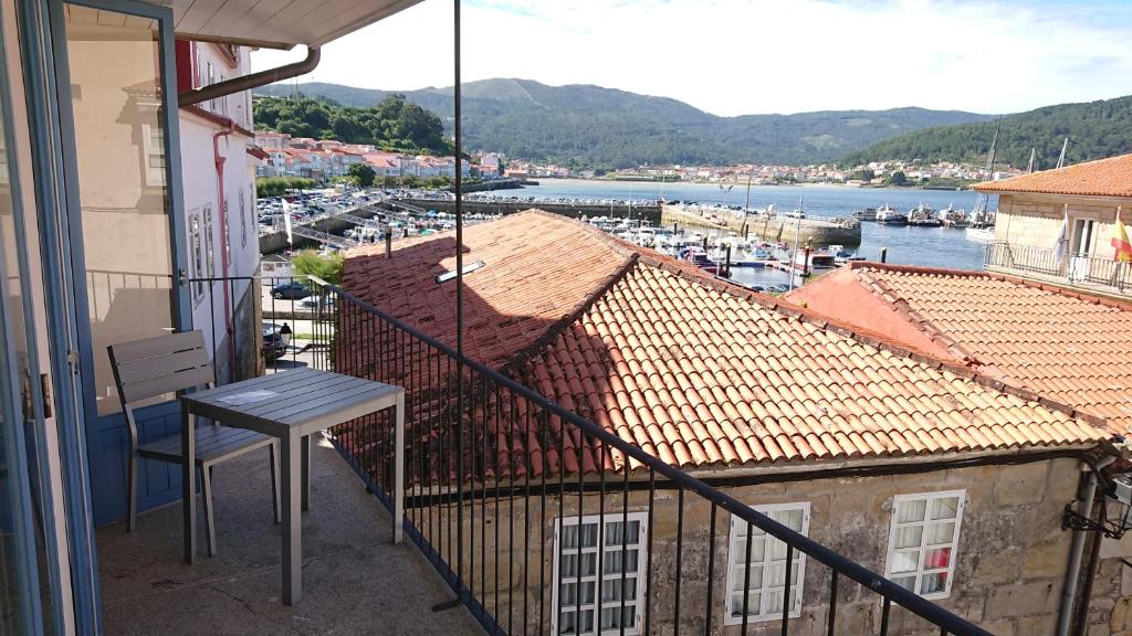 balcón con mesa y vistas al puerto en Campo da Lúa 4, en Muros