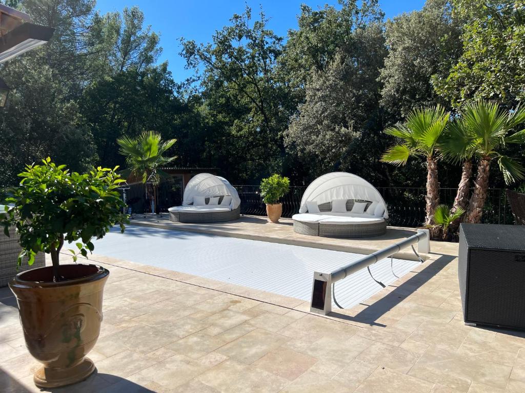 a swimming pool with two domes and palm trees at La Casa dei Sogni in Flayosc