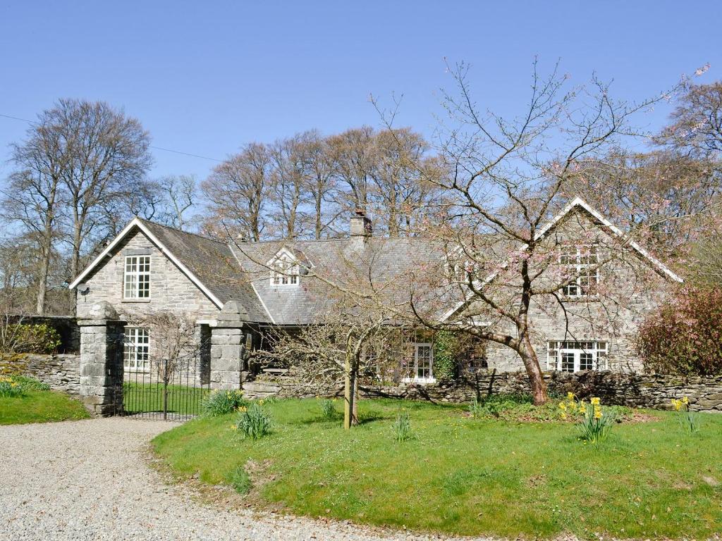 a large stone house with a gravel driveway at Crogen Coach House - Oqr in Llandrillo