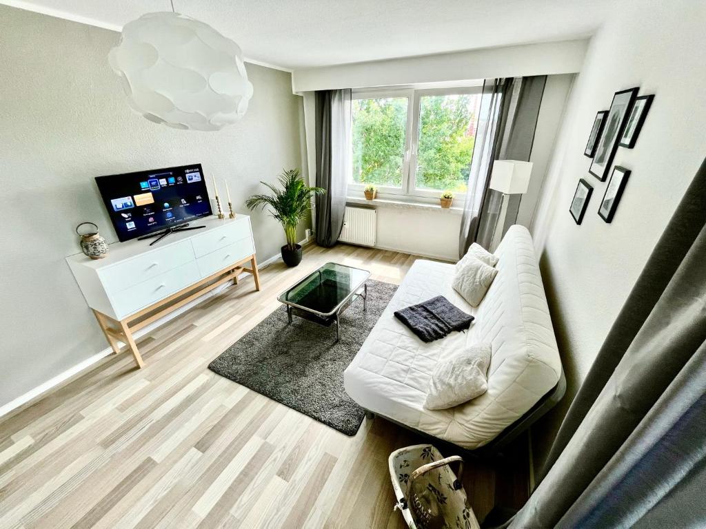 a living room with a white couch and a tv at KMHosting modern & gemütlich im Zentrum in Chemnitz