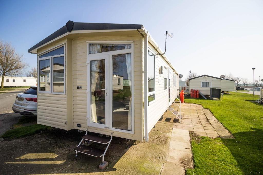 una casa pequeña está estacionada en un patio en Beautiful 8 Berth Caravan For Hire At Sand Le Mere In Yorkshire Ref 71017j en Tunstall