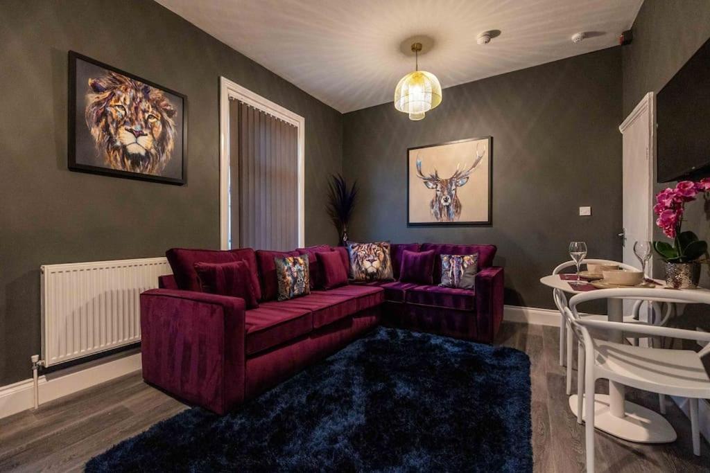 een woonkamer met een paarse bank en een tafel bij Regent Road by the V Group in Blackpool