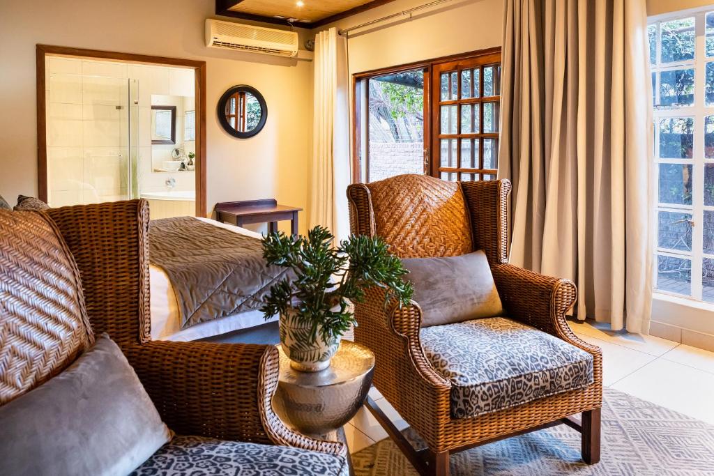 a living room with wicker chairs and a couch at Kathu Gamagara Lodge in Kathu