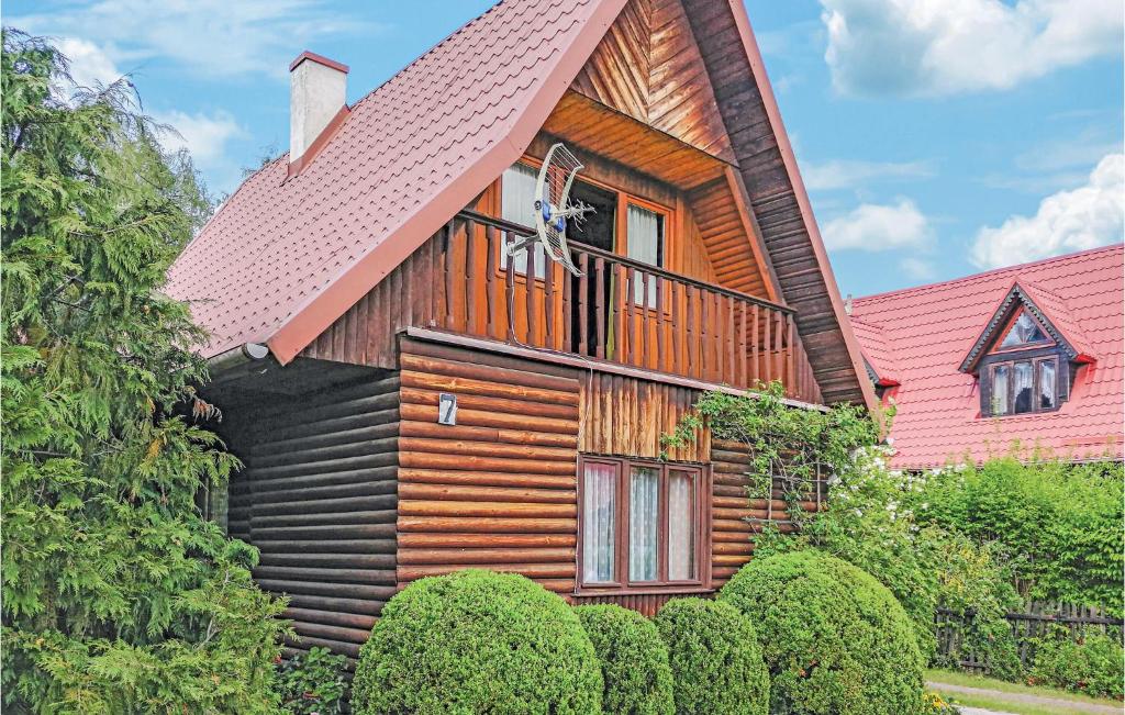 a wooden house with a red roof at Beautiful Home In Gietrzwald With 2 Bedrooms in Kręsk