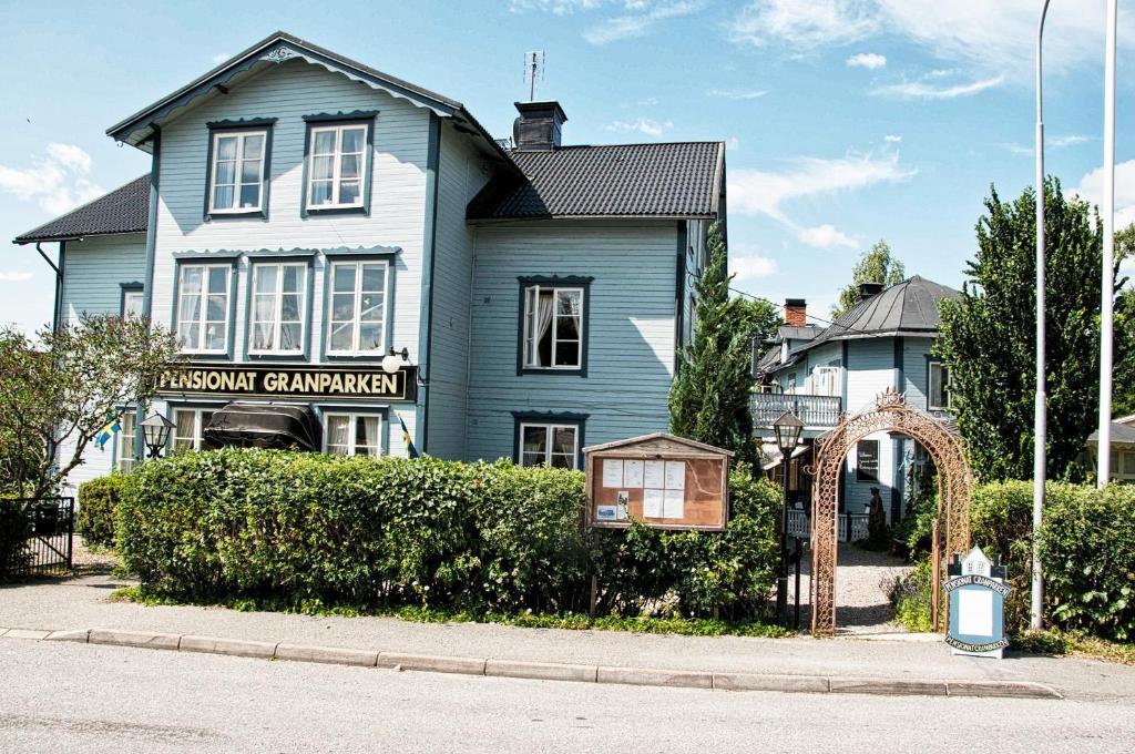 ein blaues Haus mit einem Schild davor in der Unterkunft Hotel Pensionat Granparken in Norrtälje