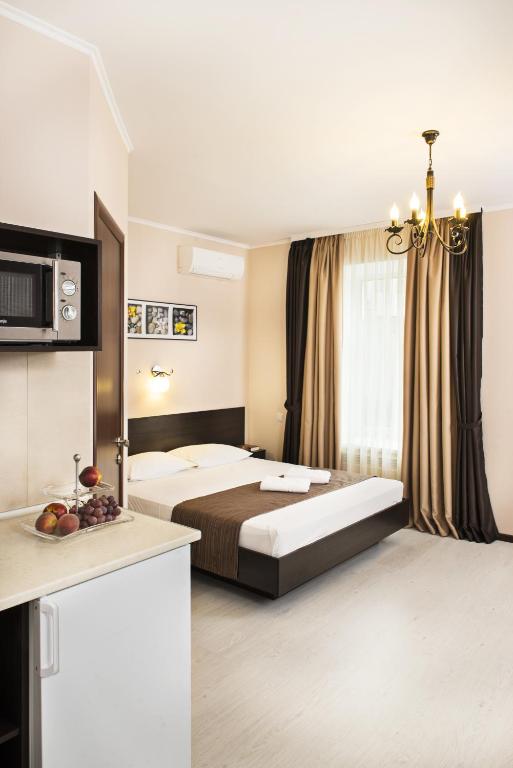a hotel room with a bed and a chandelier at Flatlux Apartments in Kyiv