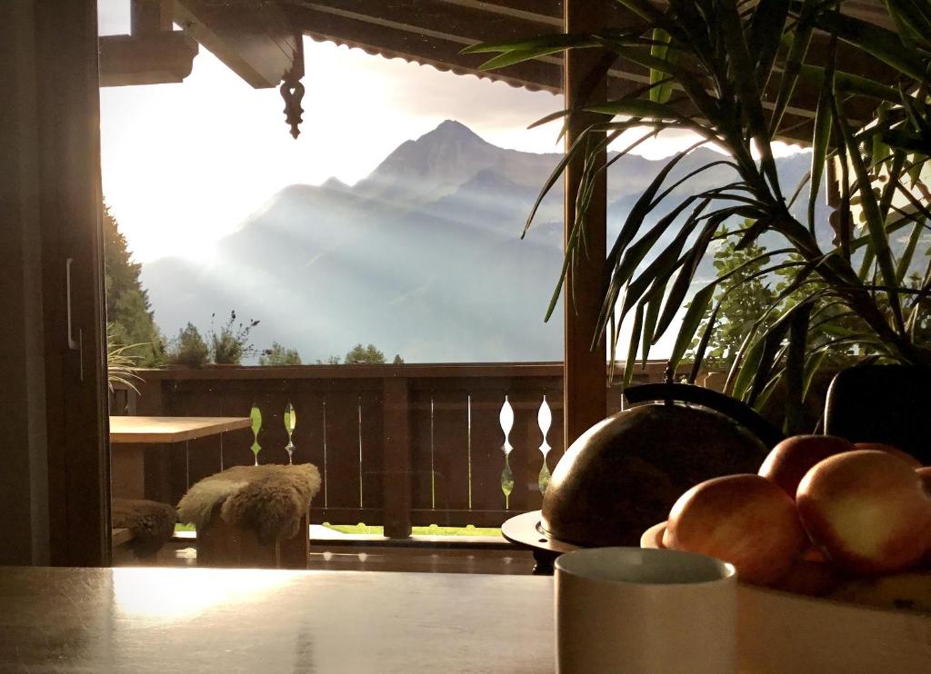un balcón con vistas a la montaña y un bol de fruta en Astegg, Apart, en Finkenberg