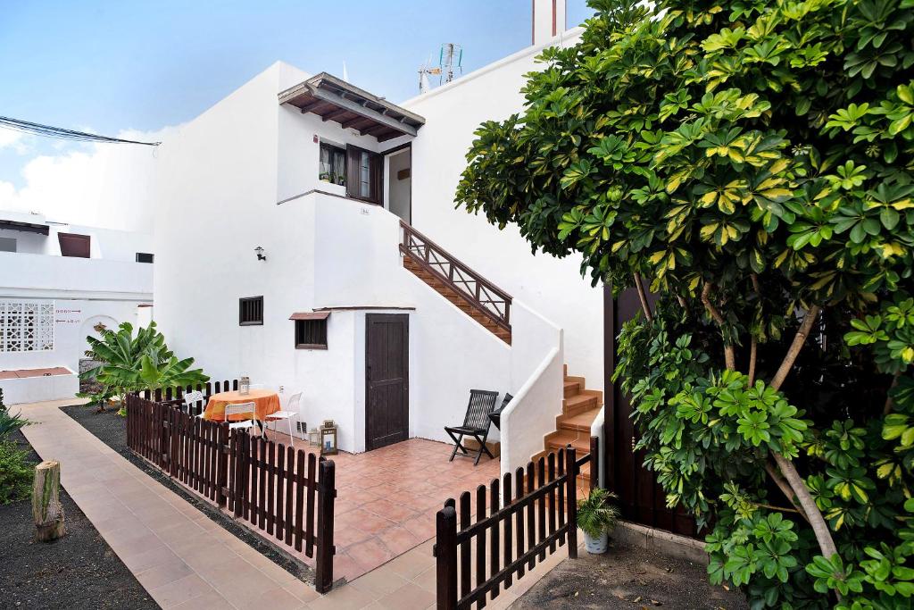 une maison blanche avec une clôture devant elle dans l'établissement Casa Luz Elena, à Puerto del Carmen