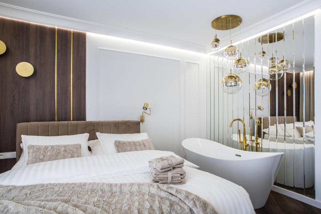 een slaapkamer met een bad, een bed en een wastafel bij Silesia Harmony in Katowice