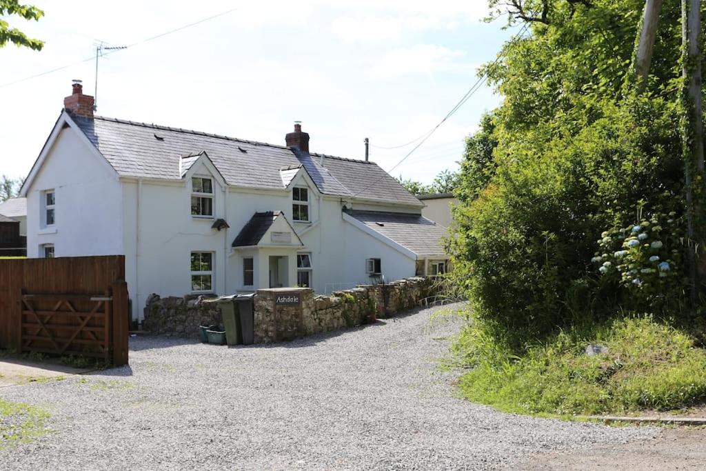 una casa blanca con una valla delante en Ashdale Cottage cosy 4 bedroom holiday home near Amroth, en Pembrokeshire
