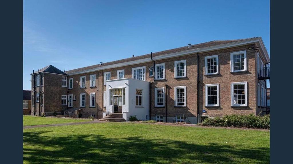 a large brick building with a lawn in front of it at The Great Western Hotel in Taunton