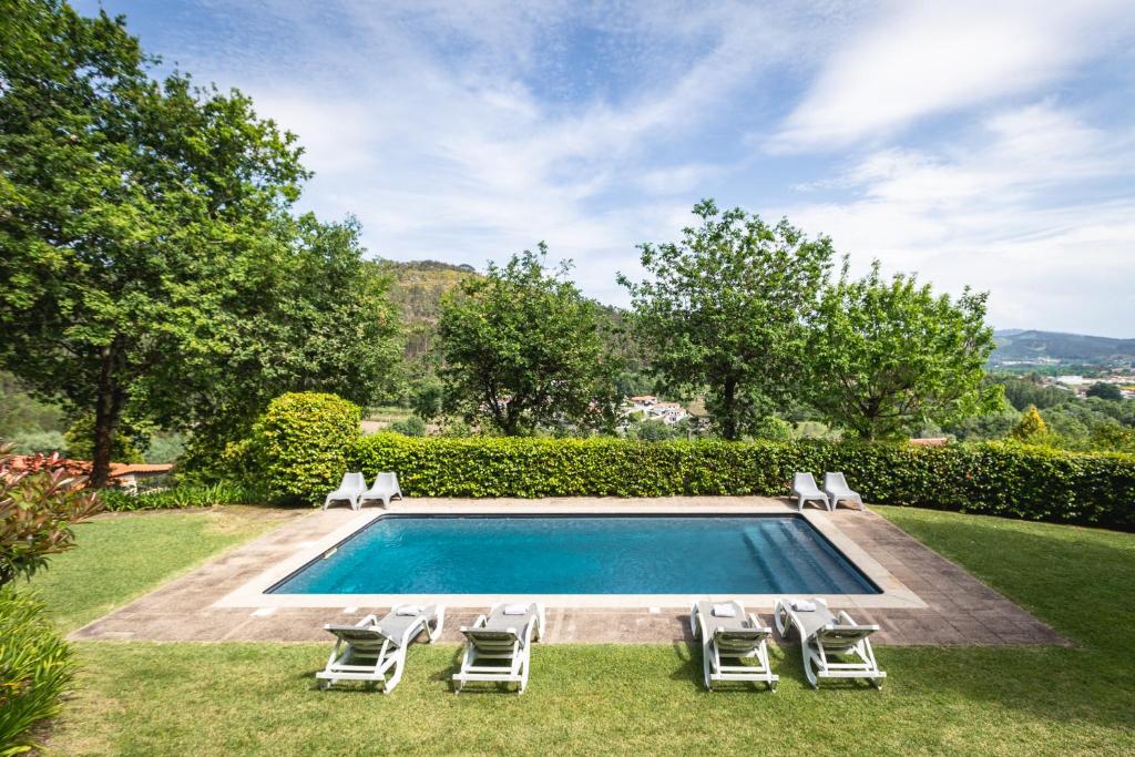 una piscina con sedie a sdraio e un piscina con piscina per il nuoto. di Casa Castel'Rei a Guimarães