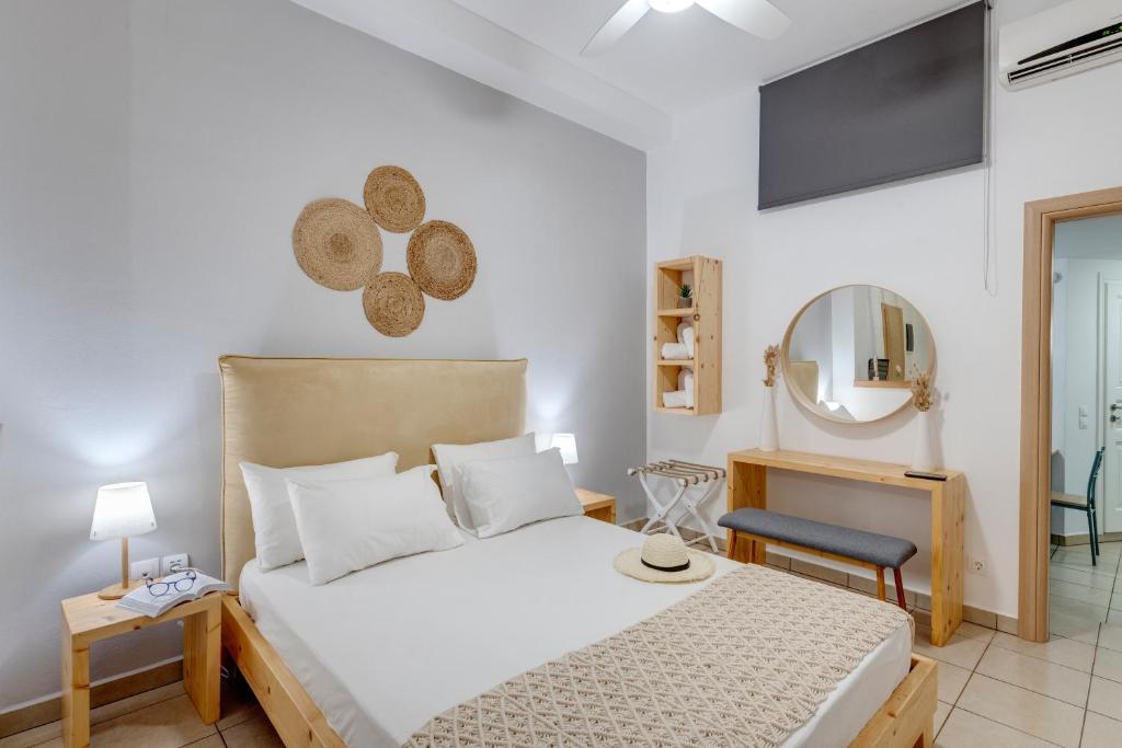 een slaapkamer met een groot bed en een spiegel bij Cova Philoxenia House in Ermoupoli