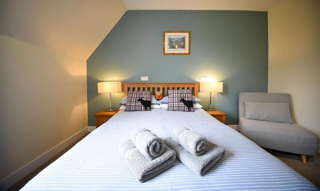 a bedroom with a large bed with towels on it at Grenitote B&B in Portree