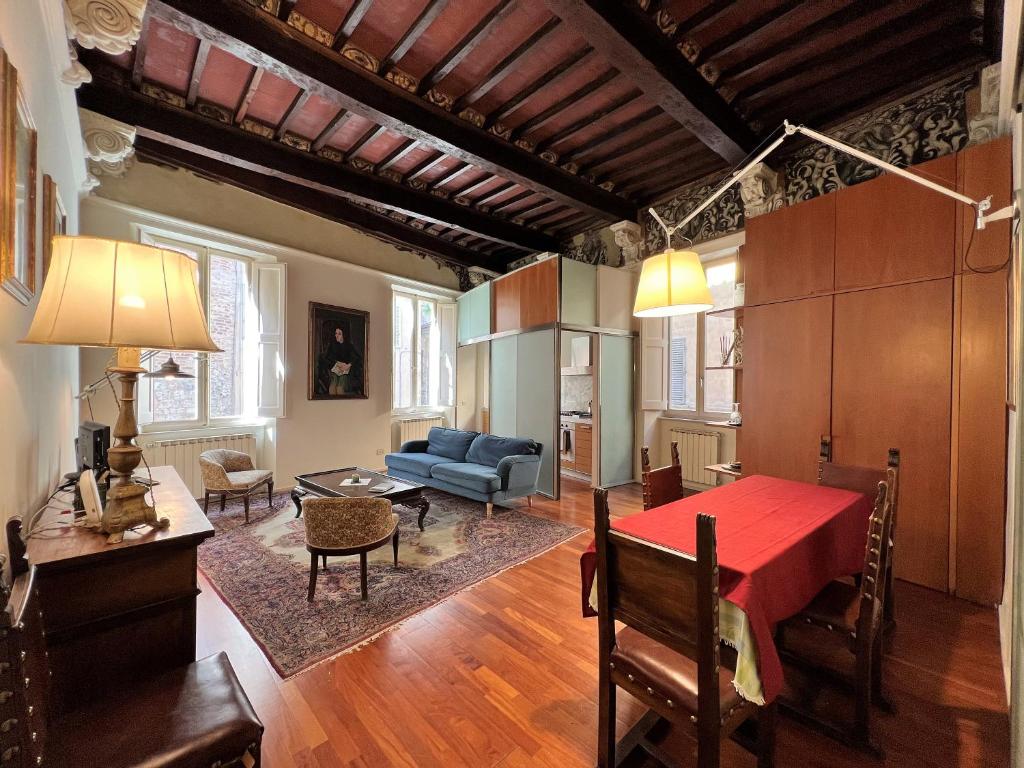 een woonkamer met een rode tafel en een bank bij Guest House Bandini: eleganza nel cuore di Siena in Siena