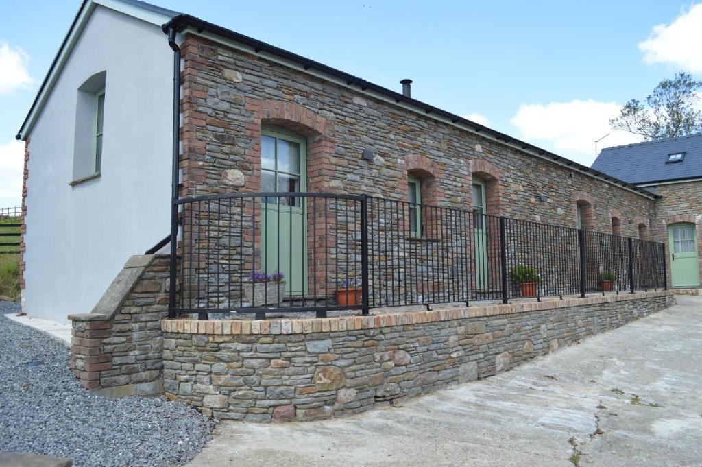 a brick retaining wall with a fence on a building at Cwrt y Wennol in Swansea