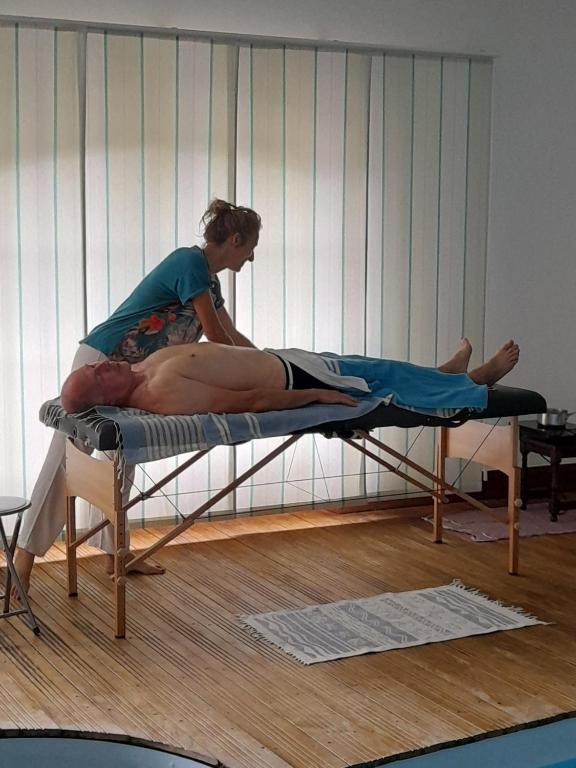 a woman sitting on a bed in a room at Auverg&#39;Nature Chambre Cocon massage ayurvédique in Espinasse