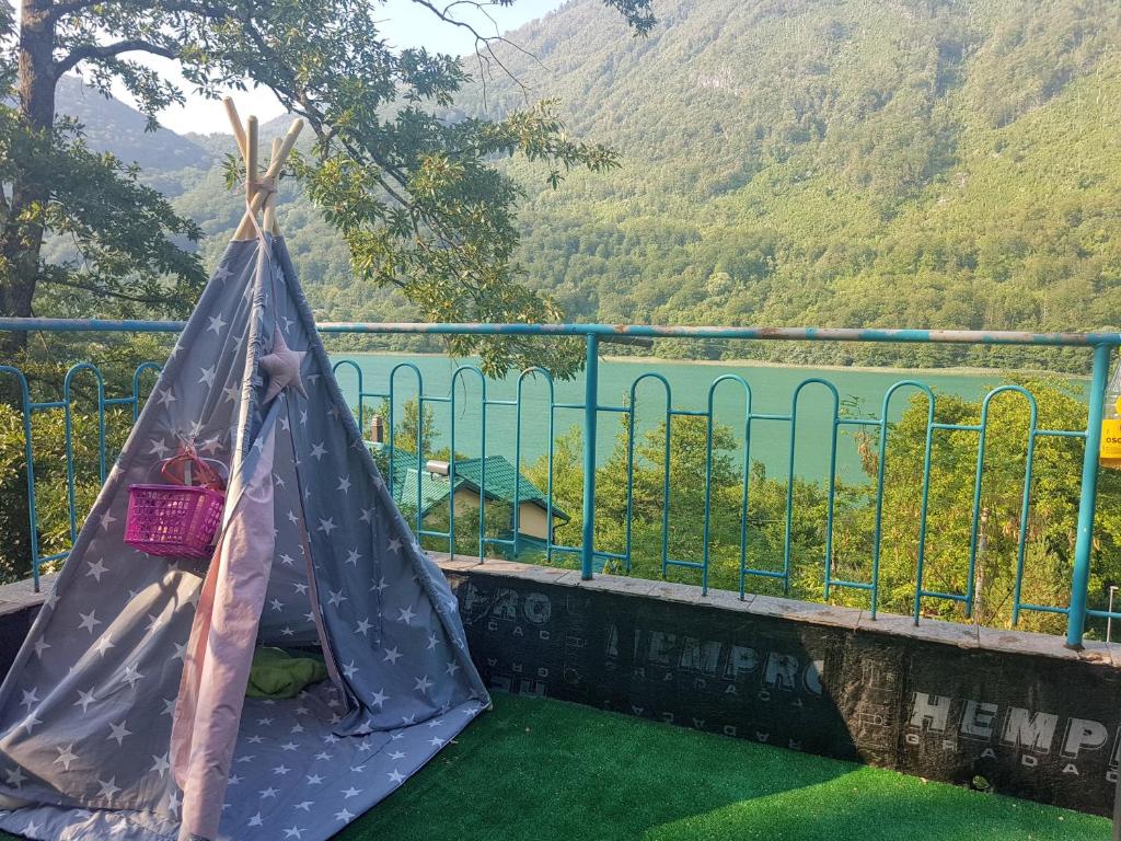 a girl in a hammock on a balcony with a view of mountains at Union apartmani Boracko jezero in Konjic