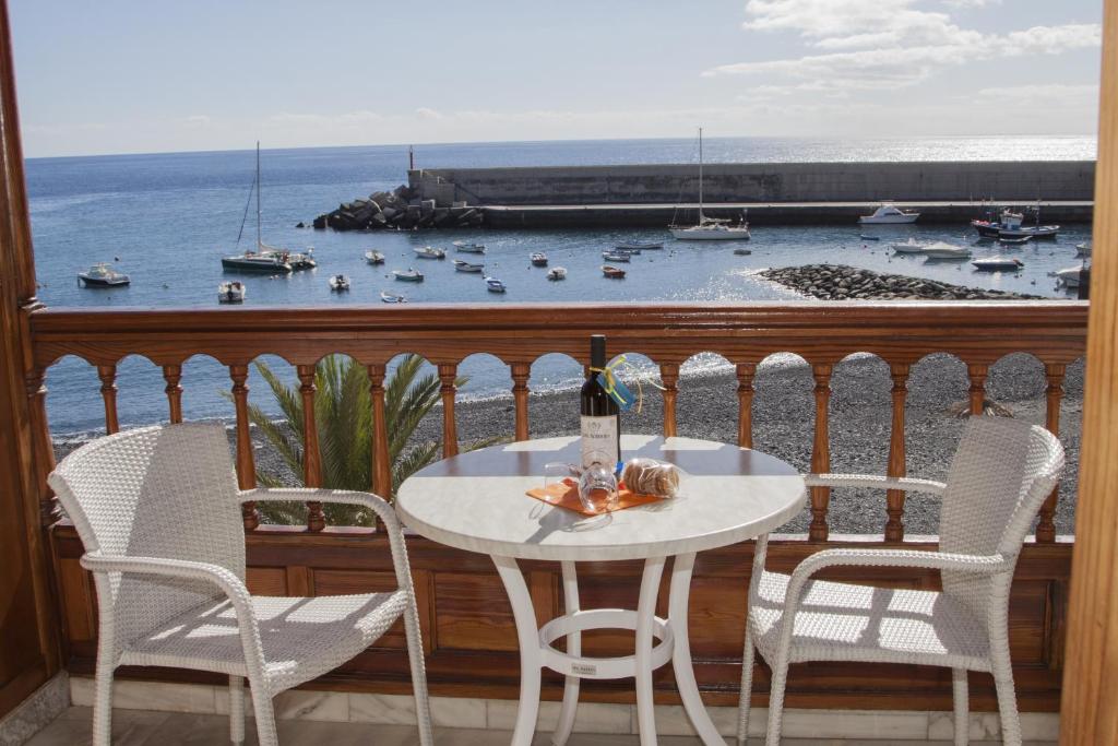 uma mesa e cadeiras numa varanda com vista para o oceano em Apartamentos Tapahuga em Playa de Santiago