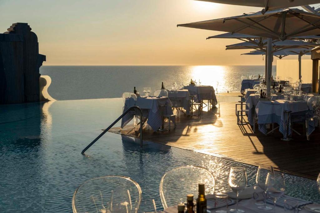 a pool with tables and chairs in the water at Grand Hotel Principe Di Piemonte in Viareggio