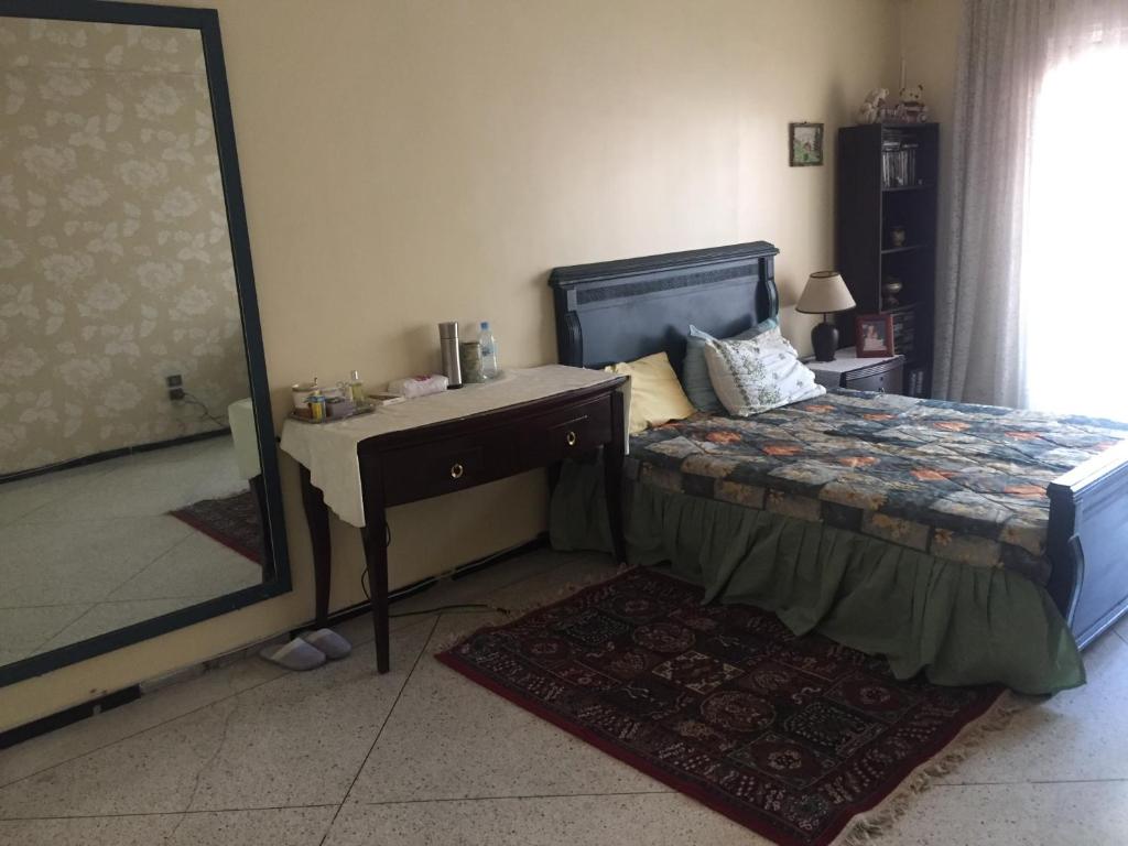 a bedroom with a bed and a desk and a mirror at Room in Guest room - Property located in a quiet area close to the train station and town in Casablanca