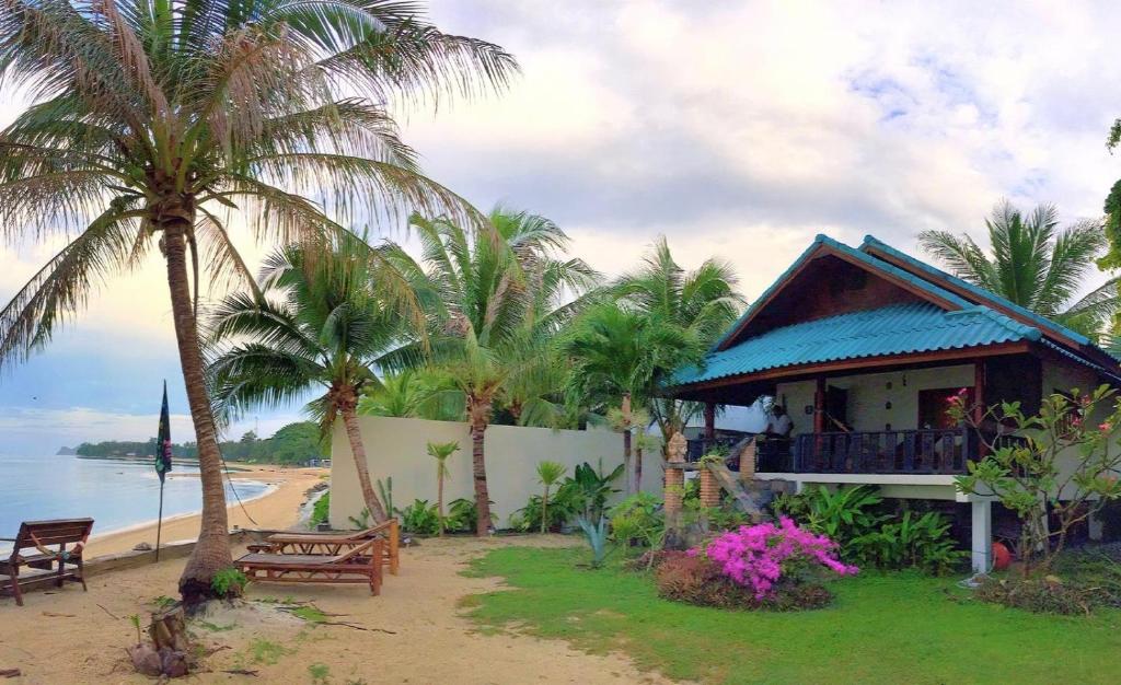 a house on the beach with palm trees at Three rare & private front beach villas in Thongsala