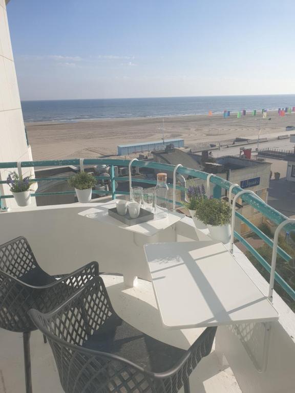 einen Balkon mit Tisch und Stühlen sowie Strand in der Unterkunft studio Vue mer au cœur de malo les bains pieds dans l eau in Dunkerque