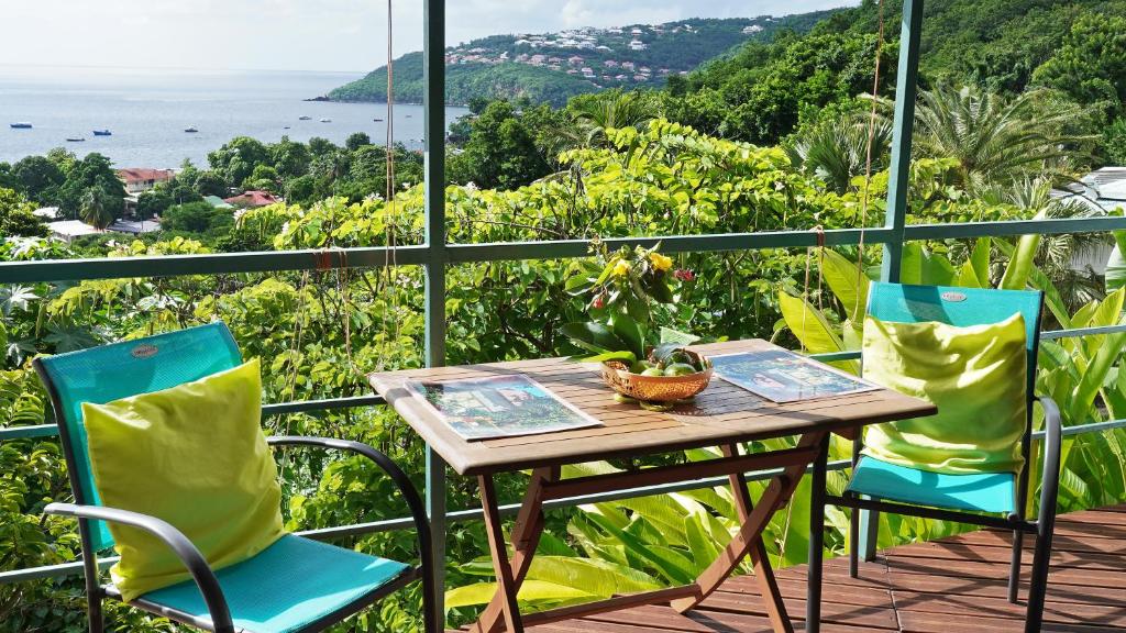 stół i krzesła na balkonie z widokiem na ocean w obiekcie KAZ AMOUR w mieście Bouillante