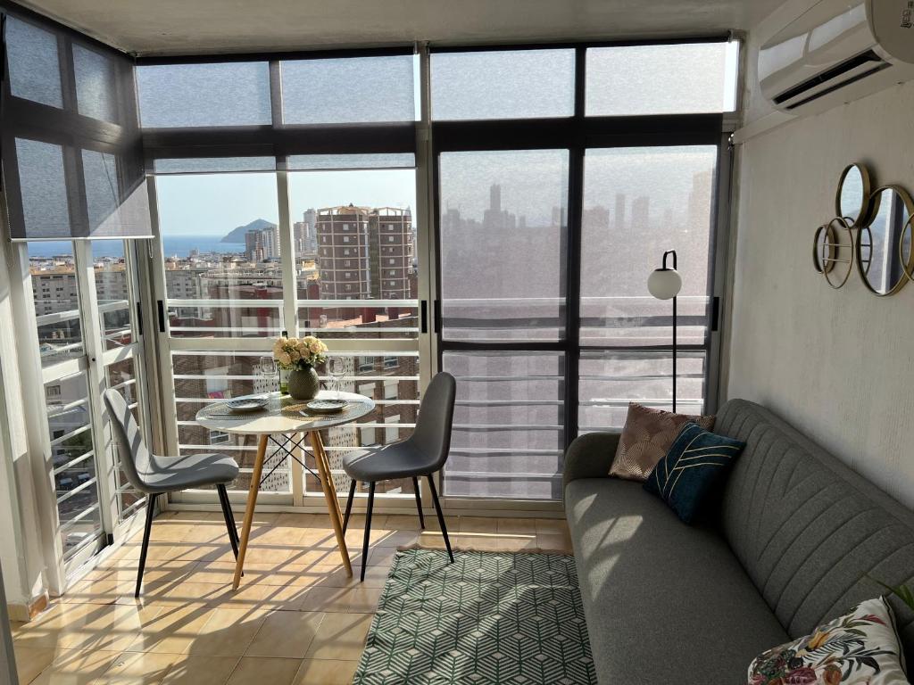 a living room with a couch and a table with chairs at Панорамная квартира с 1 спальней в Бенидорме in Benidorm