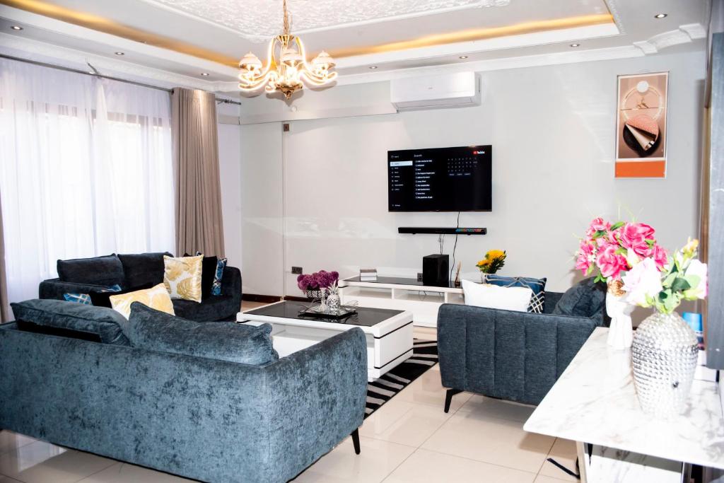 a living room with two blue couches and a tv at Lusaka Luxe - Your Private Oasis Awaits in the Heart of Zambia in Lusaka