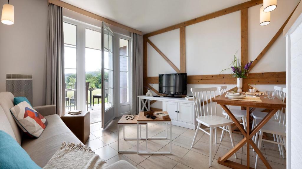 a living room with a couch and a table at Pierre & Vacances Premium Residence & Spa Houlgate in Houlgate