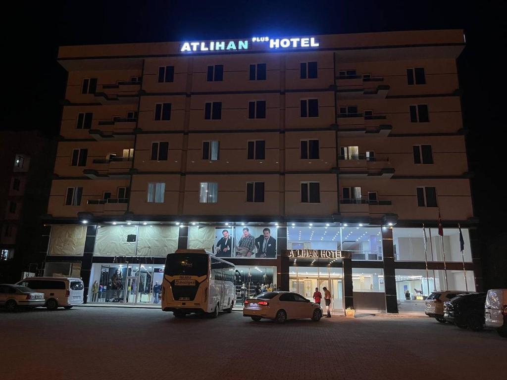 ATLIHAN PLUS HOTEL في دوغوبايازيت: فندق في الليل فيه سيارات تقف امامه