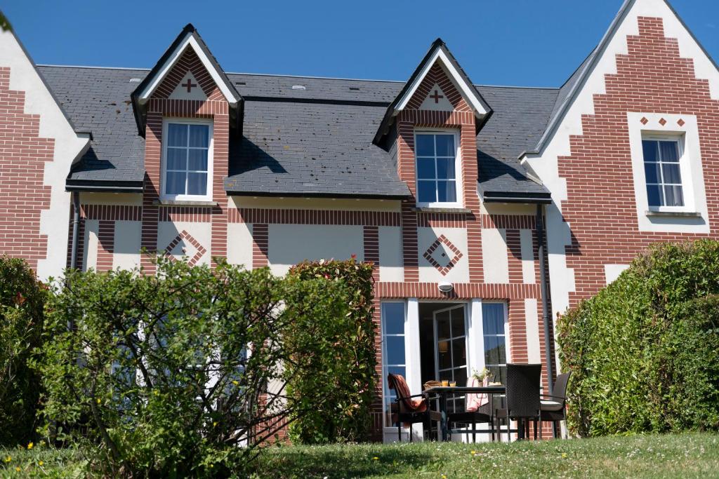 a brick house with a table in front of it at Pierre & Vacances Premium Residence & Spa Houlgate in Houlgate
