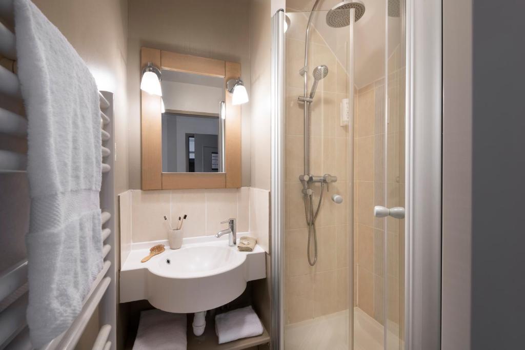 a bathroom with a sink and a shower at Pierre & Vacances Premium Residence & Spa Houlgate in Houlgate