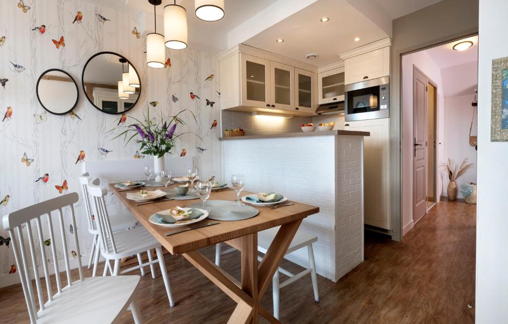a kitchen and dining room with a wooden table and chairs at Pierre & Vacances Premium Residence & Spa Houlgate in Houlgate