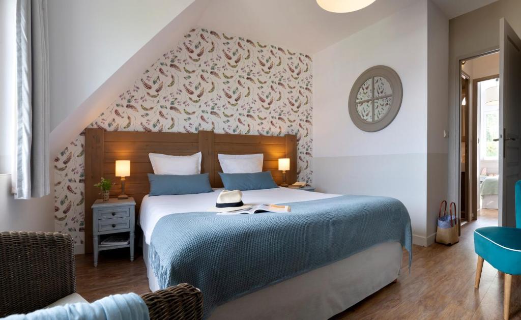 a bedroom with a large bed with a blue blanket at Pierre & Vacances Premium Residence & Spa Houlgate in Houlgate