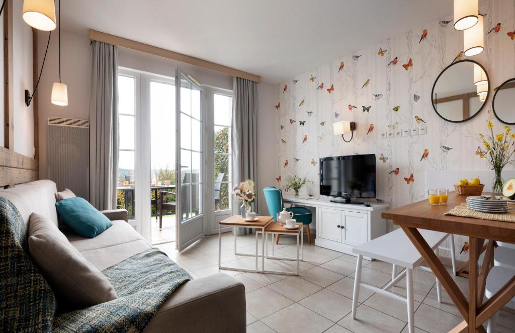 a living room with a couch and a table at Pierre & Vacances Premium Residence & Spa Houlgate in Houlgate