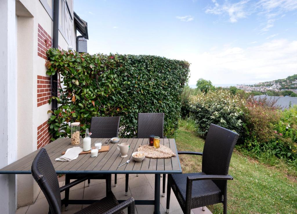 a table and chairs sitting on a patio at Pierre & Vacances Premium Residence & Spa Houlgate in Houlgate