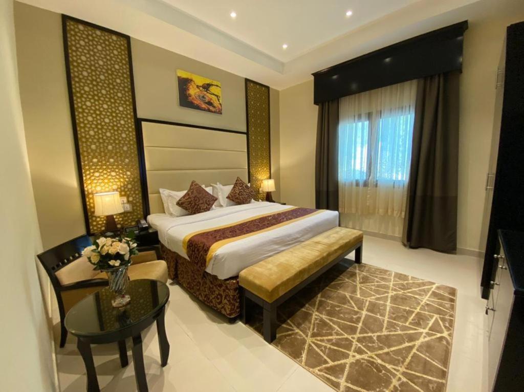 a hotel room with a bed and a table and a table sidx sidx at Western Hotel - Madinat Zayed in Madīnat Zāyid