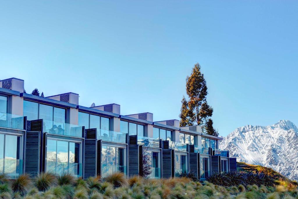 
a large building with trees and a sky background at Swiss-Belsuites Pounamu Queenstown in Queenstown

