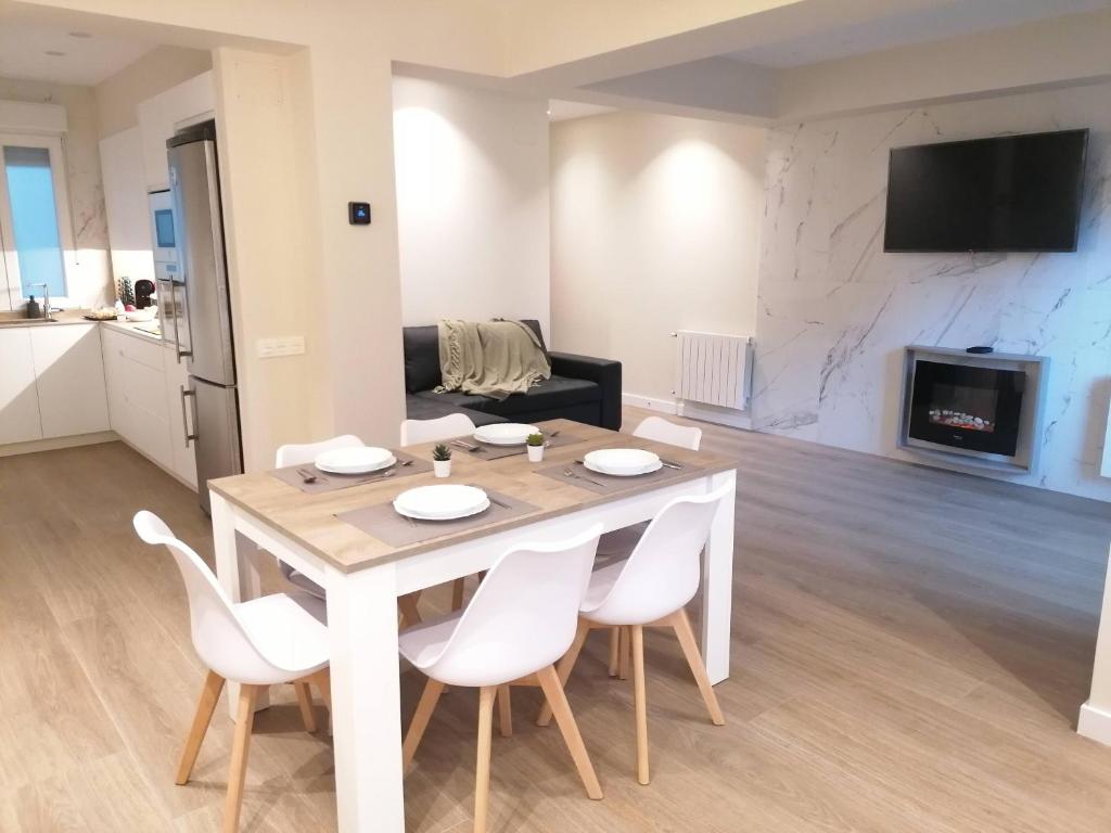 cocina y sala de estar con mesa de madera y sillas en APARTAMENTO CALMA, en Logroño