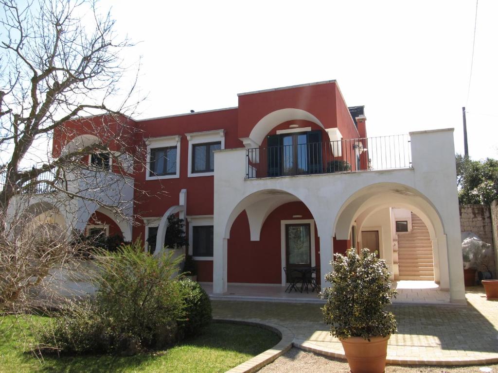 a red and white house with a balcony at Relais Casabella in Martina Franca