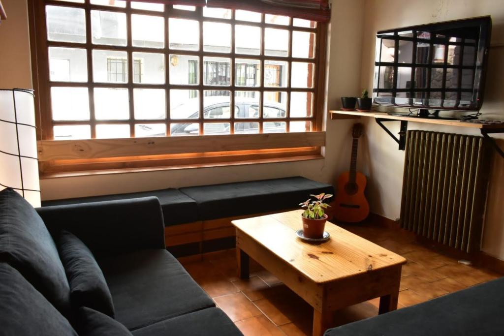 a living room with a couch and a table and a window at Cinerama Hostel in San Carlos de Bariloche