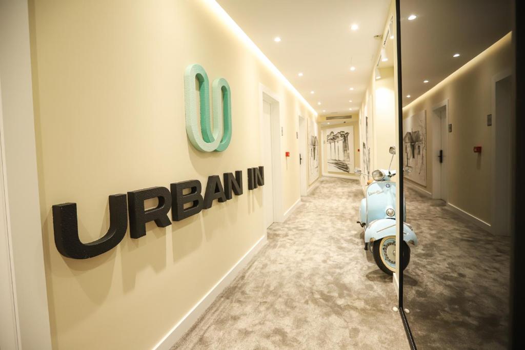 un pasillo con una moto azul estacionada en un edificio en Urbanin Apartment & Hotel, en Tirana