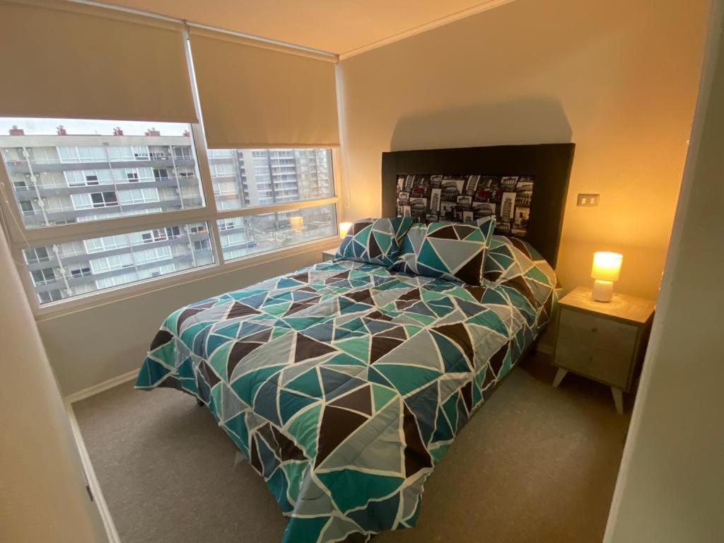 Un dormitorio con una cama grande y una ventana en Bellísimo y centrico apartamento en La Serena en La Serena